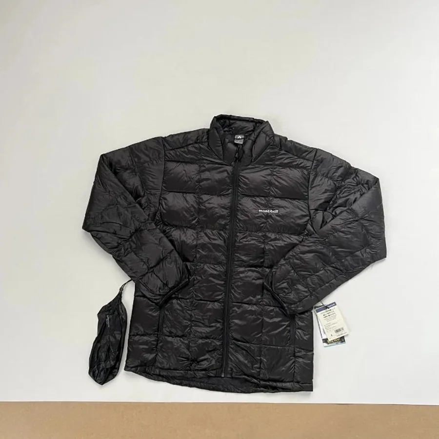 Black lightweight down jacket laid flat with its storage pouch