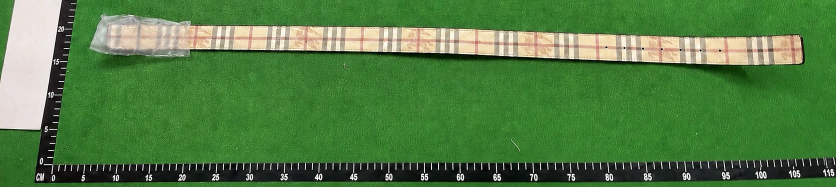 Real QC photo showing the complete checked belt with the left and bottom centimetre rulers visible